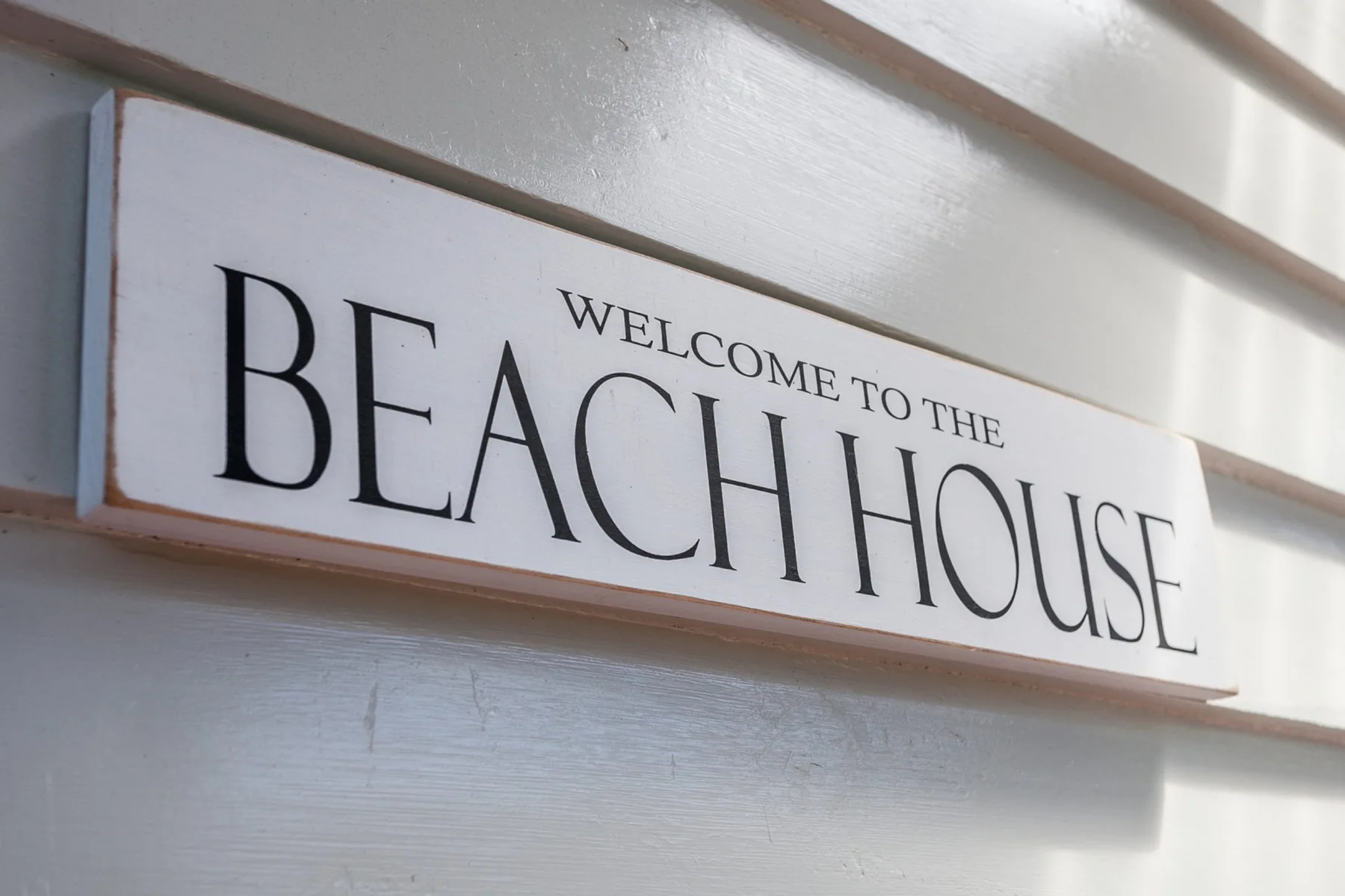 Un letrero en la pared dice «Bienvenidos a la casa de playa».