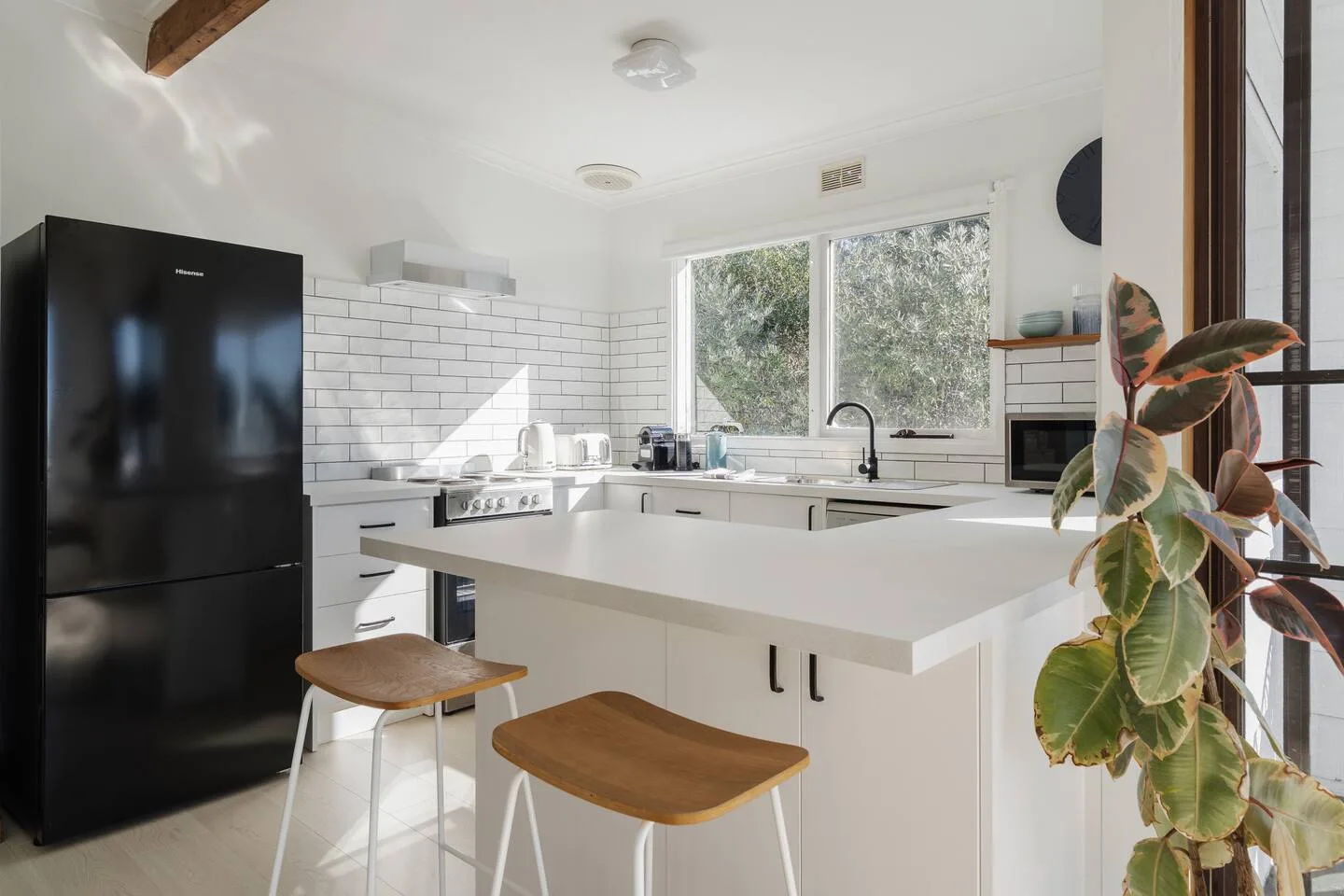 Una cocina luminosa con una isla grande y ventanas con vistas a la vegetación.