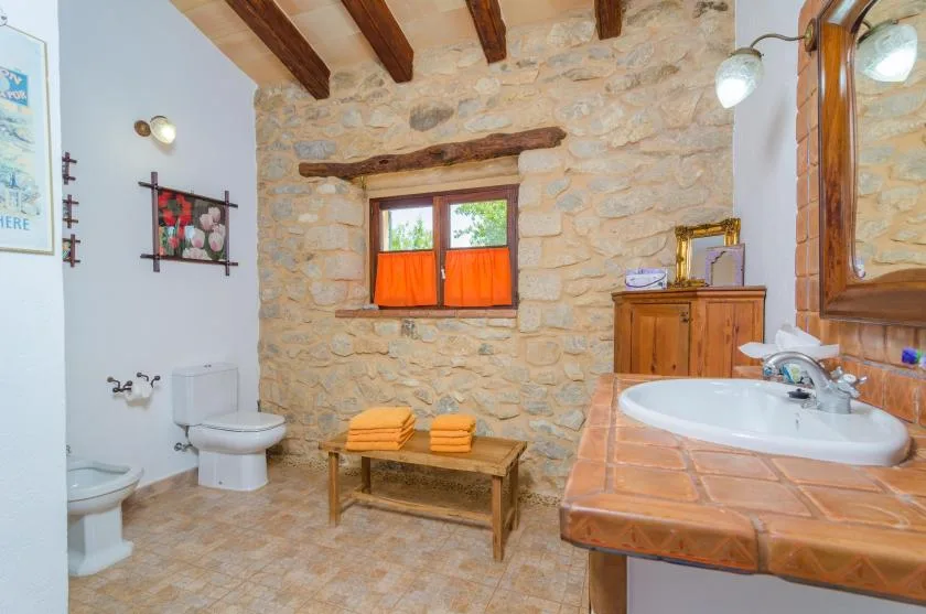 Un baño rústico con bañera, lavabo y una ventana pequeña.