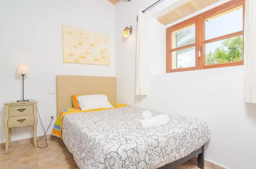 Un dormitorio con una cama doble junto a una ventana grande.