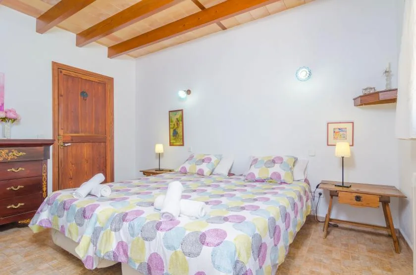 Un dormitorio con dos camas cubiertas con ropa de cama estampada y colorida.