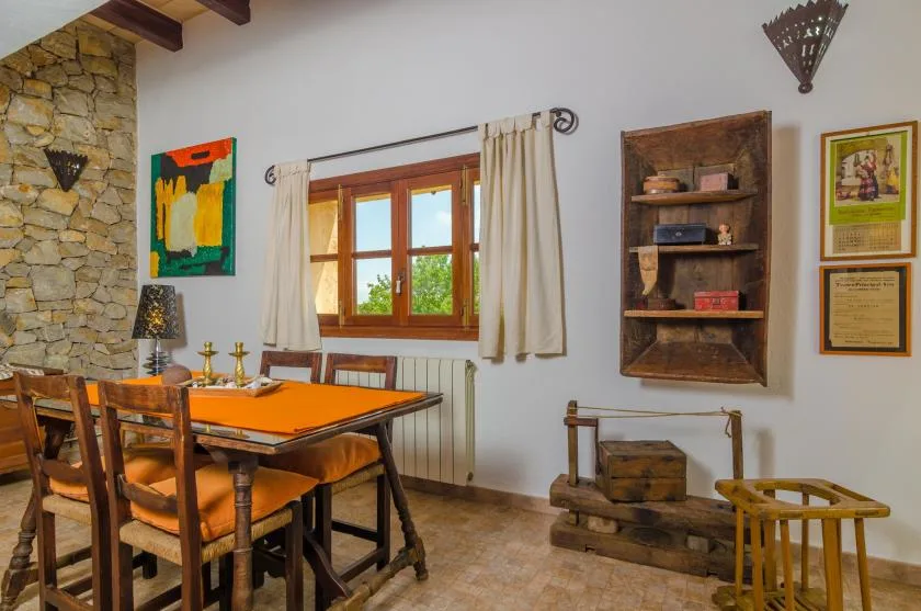 Comedor rústico con una mesa de madera junto a una ventana.