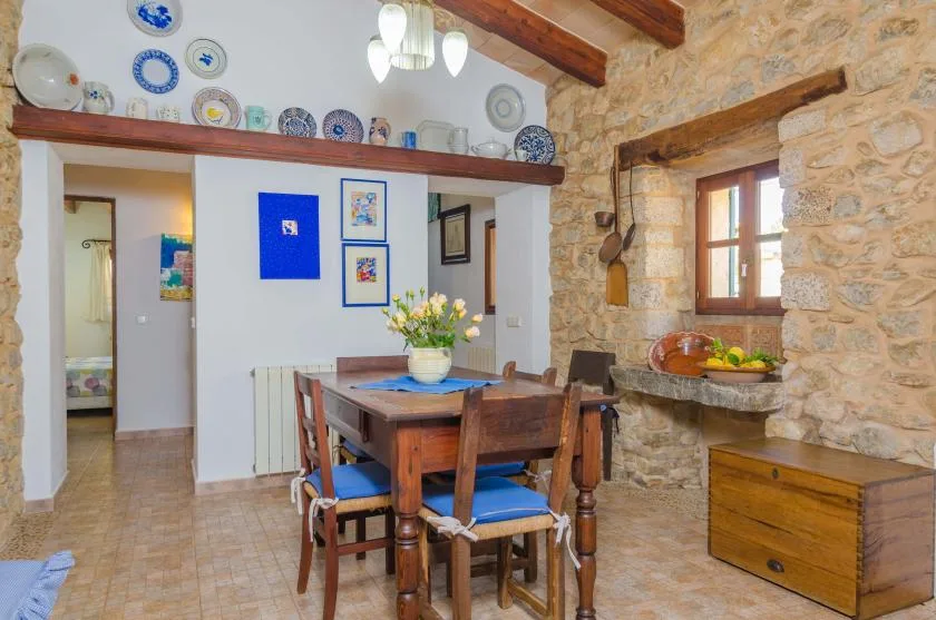 Un comedor rústico con una mesa y sillas de madera bajo vigas expuestas.