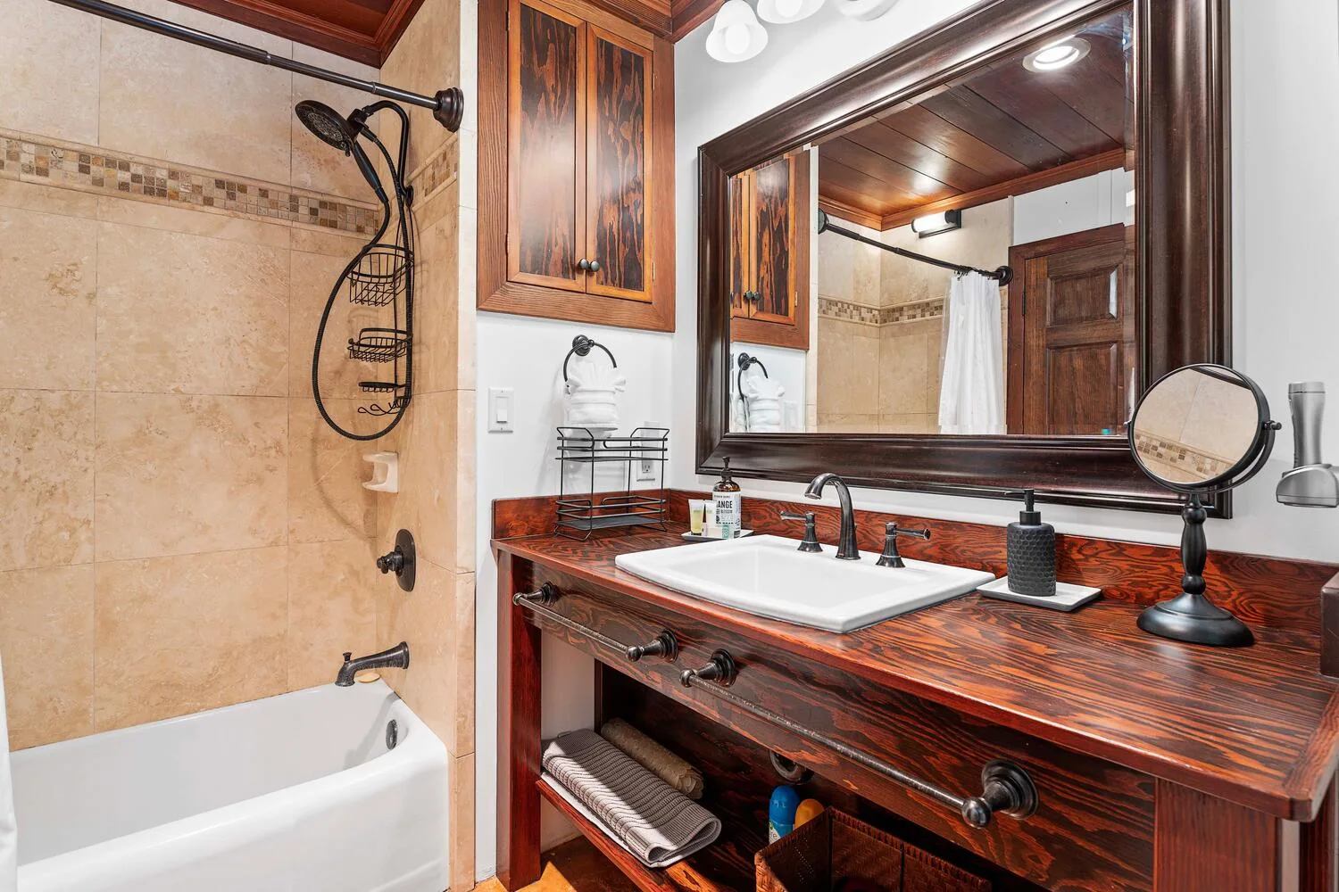 Un mueble de baño con lavabo está junto a una bañera y ducha con azulejos.
