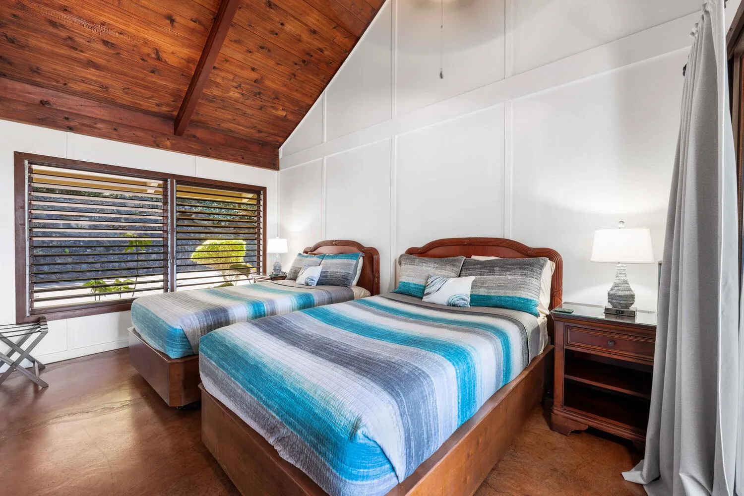 Un dormitorio con dos camas vestidas con ropa de cama a rayas azules y blancas.