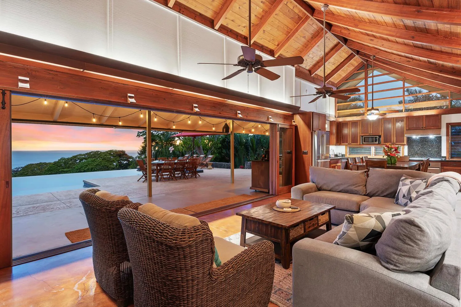 Una sala de estar se abre a un patio, con asientos y un comedor al fondo.