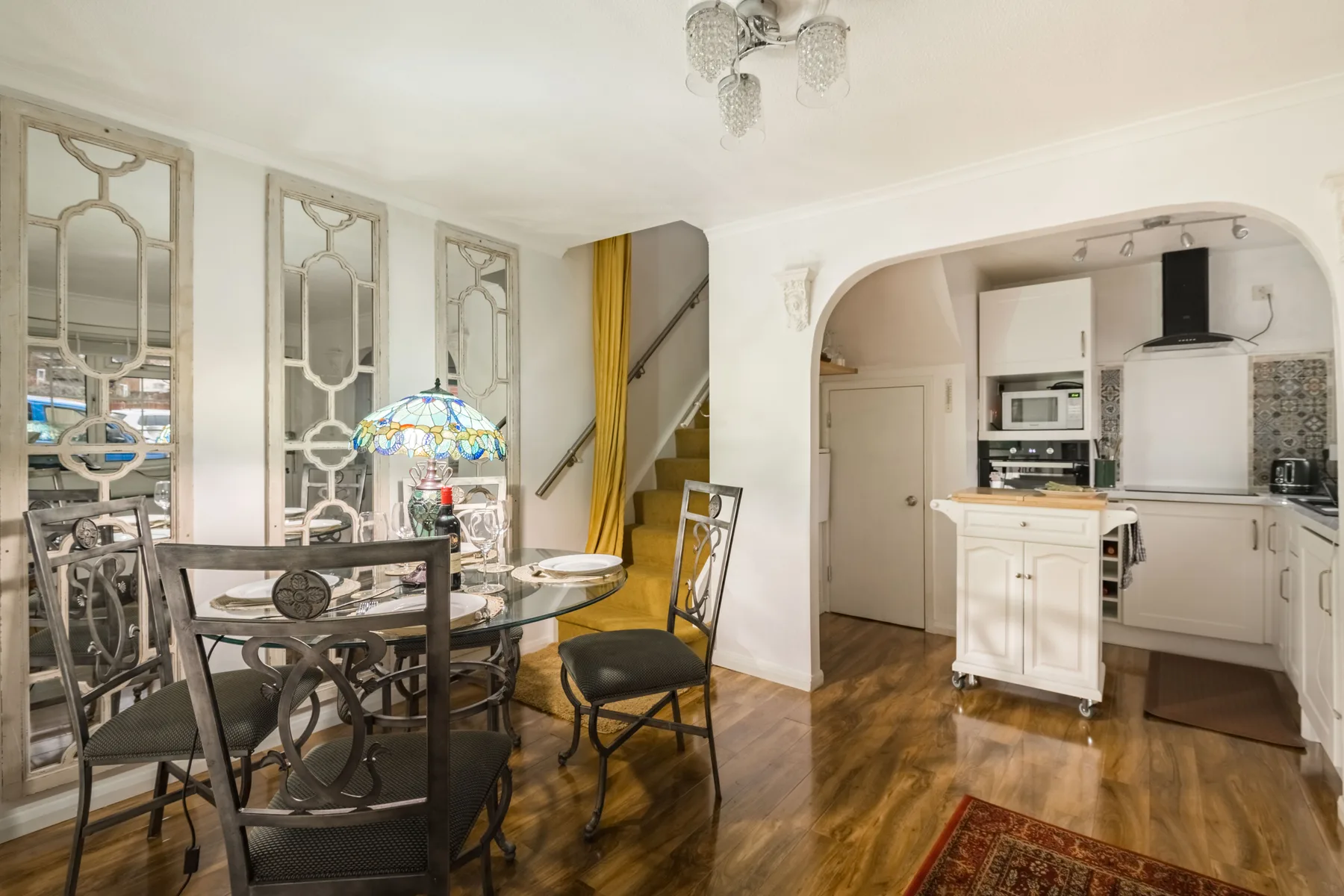 Un comedor se abre a una cocina, con una mesa y sillas junto a la isla.