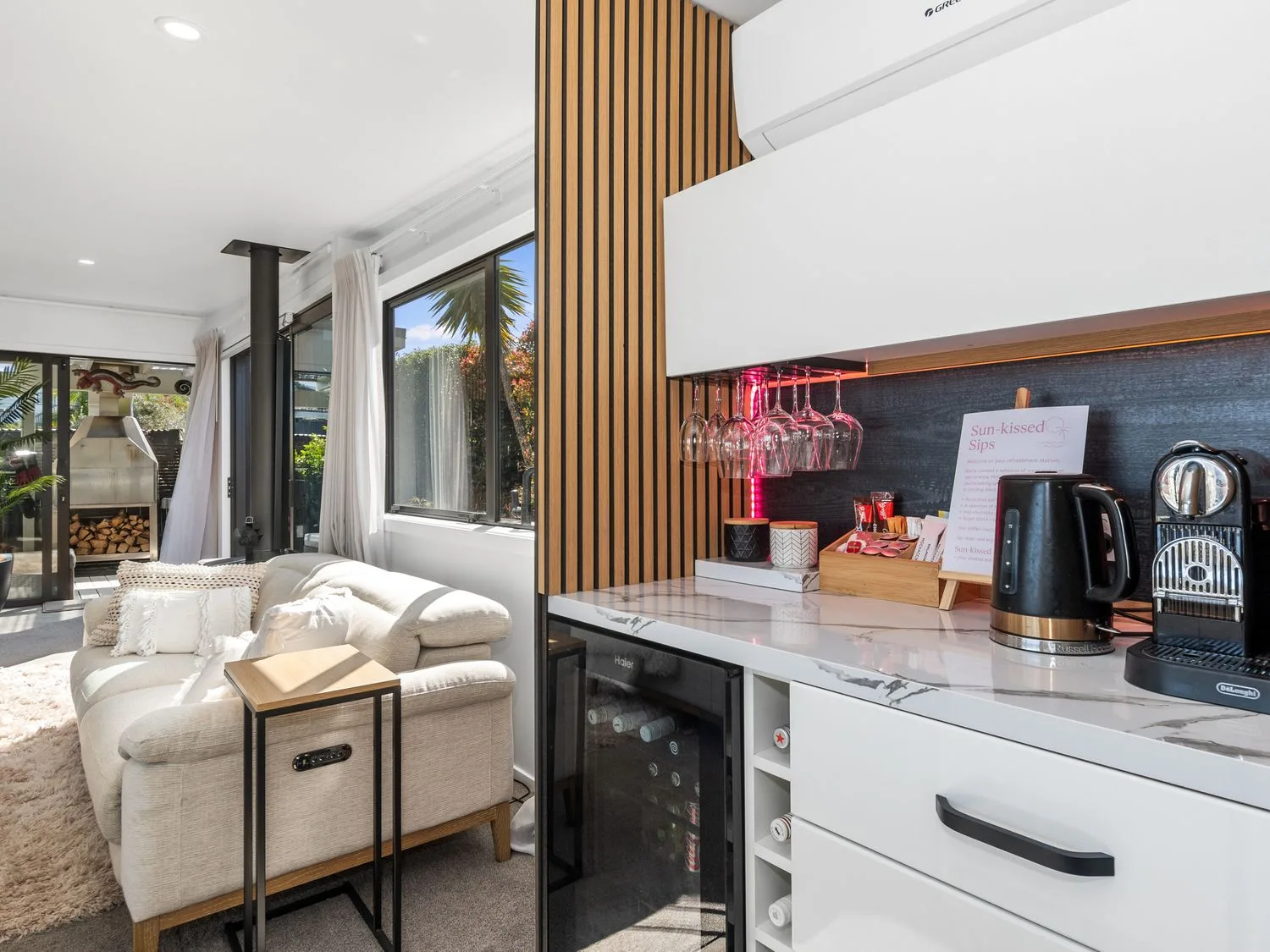 Una sala de estar con un sofá y una zona para preparar café en Sun Kissed Pool Villa - Mangawhai Heads