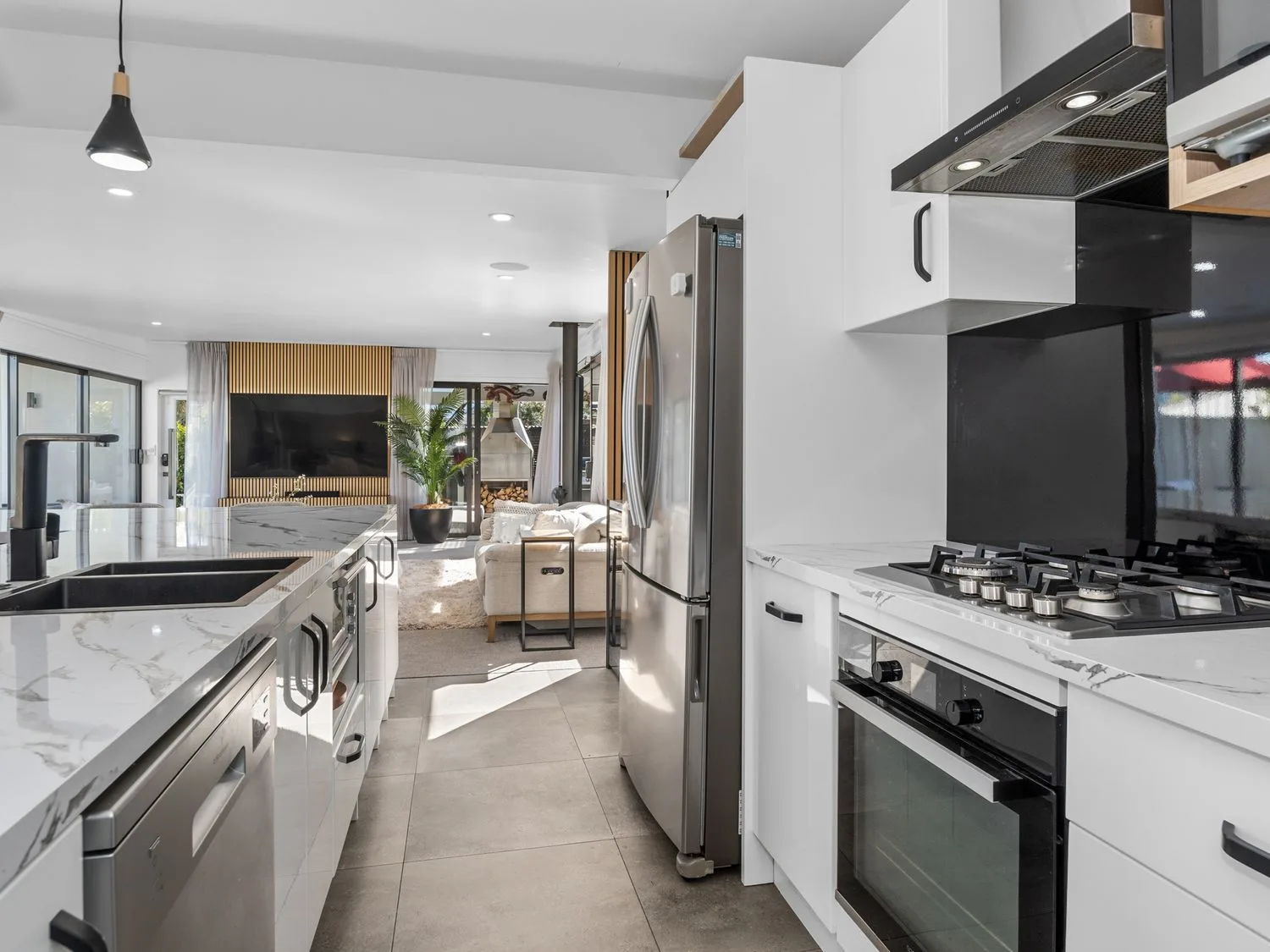 Una cocina moderna con una isla larga y electrodomésticos de acero inoxidable.