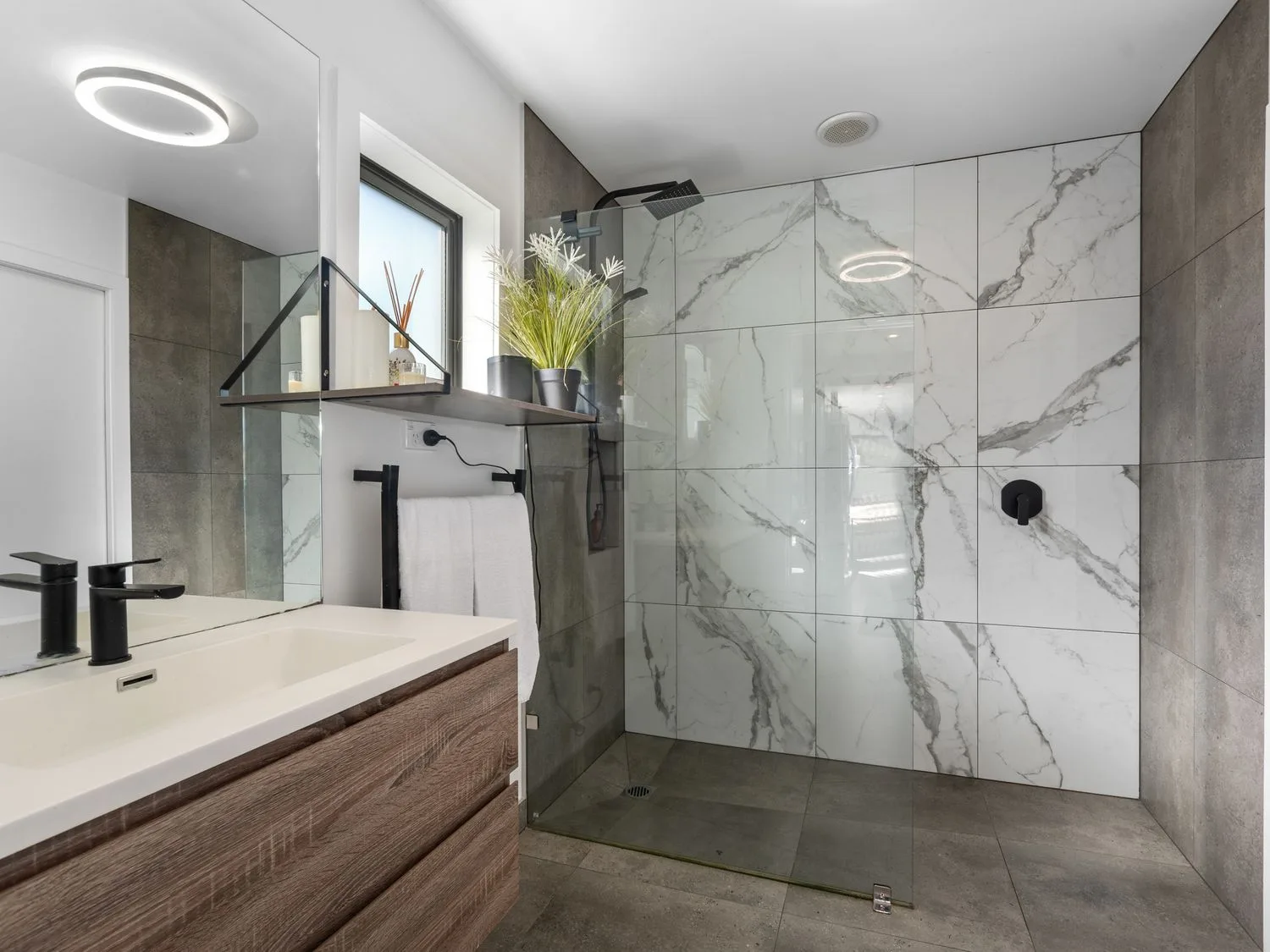 Un baño con ducha, lavabo y toallero en Sun Kissed Pool Villa - Mangawhai Heads