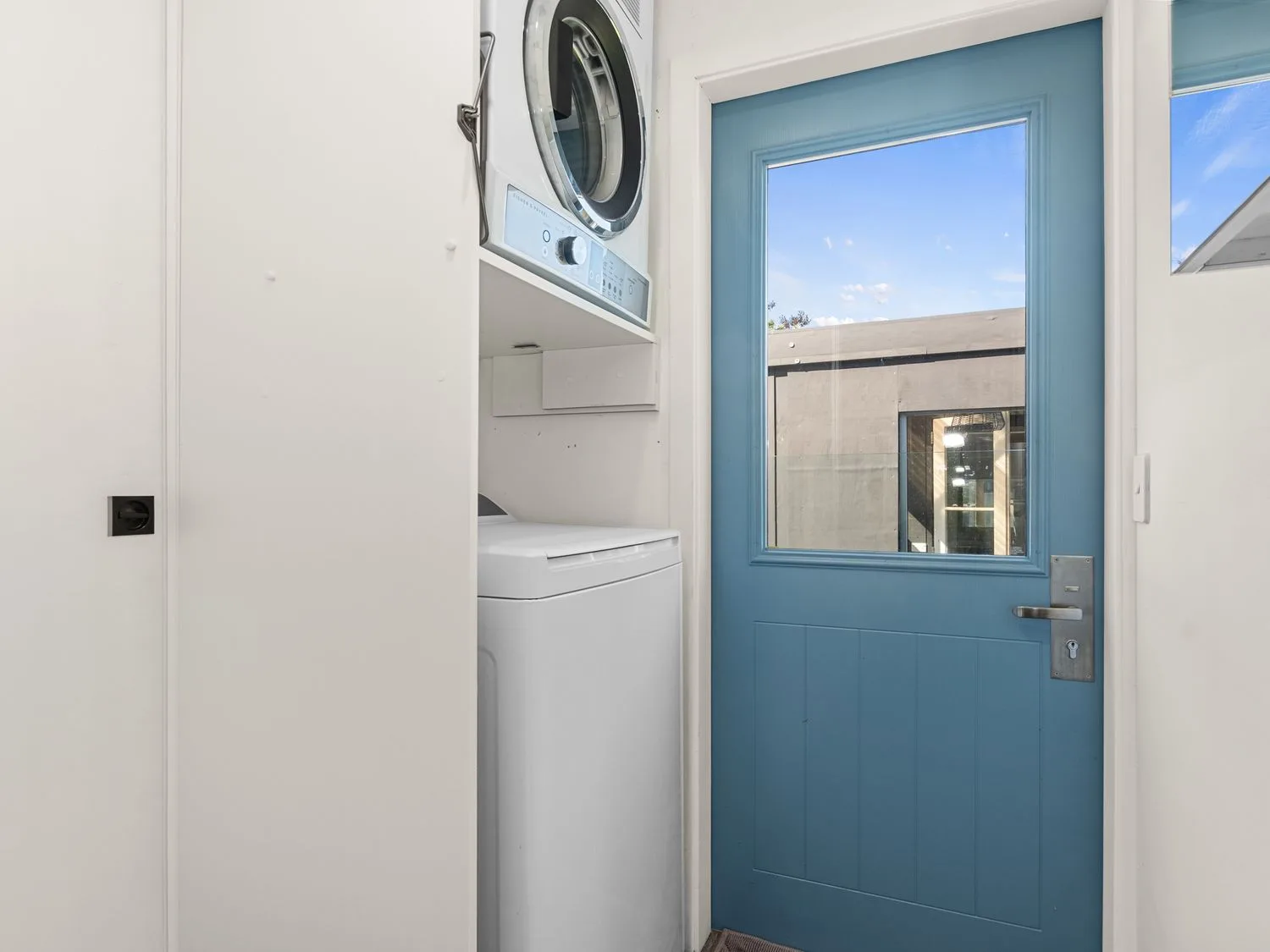 Un cuarto de lavado con lavadora y secadora en Sun Kissed Pool Villa - Mangawhai Heads