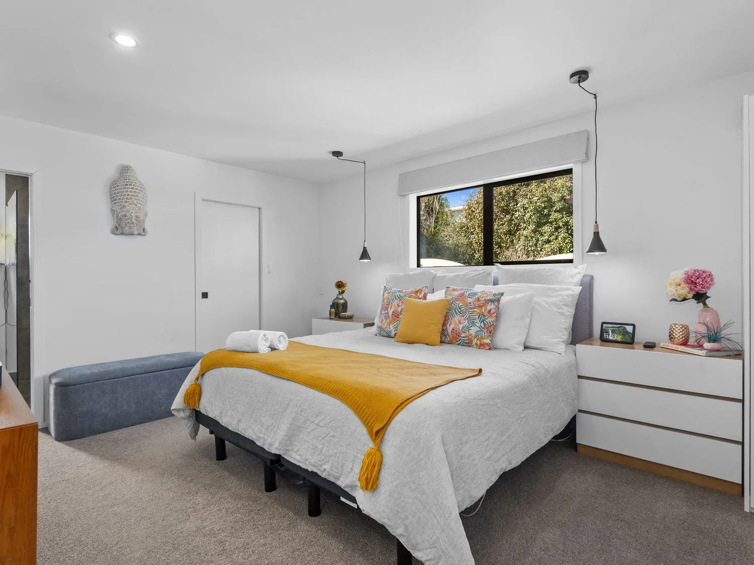 Un dormitorio con una cama y una mesa de noche en Sun Kissed Pool Villa - Casa de vacaciones en Mangawhai, Mangawhai Heads