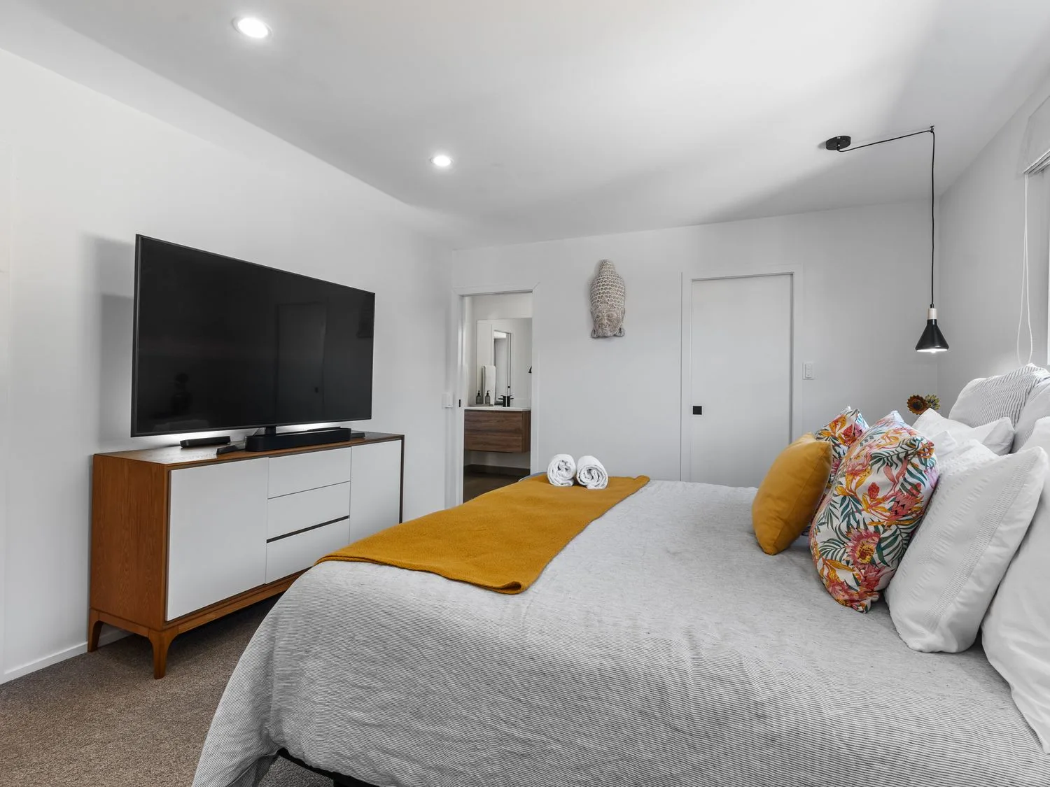 Un dormitorio con un televisor y una cama en Sun Kissed Pool Villa - Mangawhai Heads