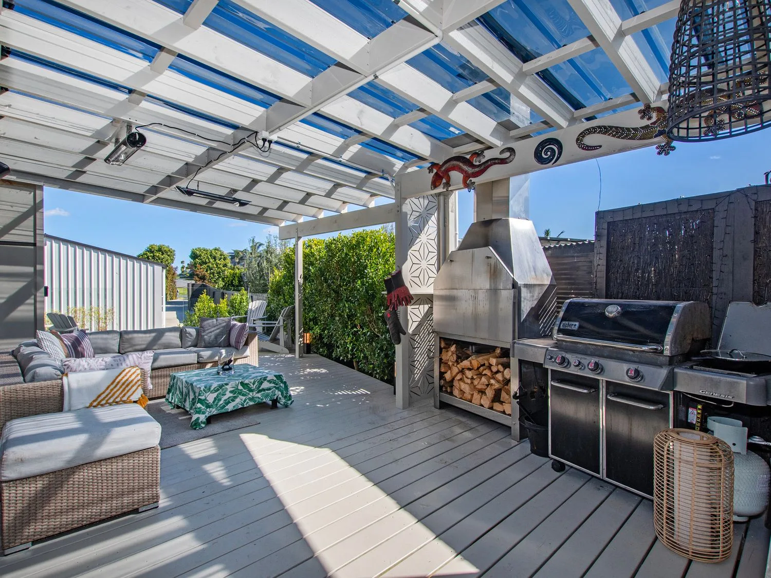 Un patio exterior con asientos y una parrilla en Sun Kissed Pool Villa - Mangawhai Heads