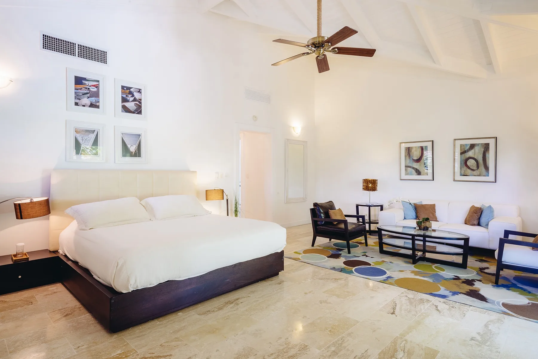 Un dormitorio luminoso con una cama grande y una zona de estar.