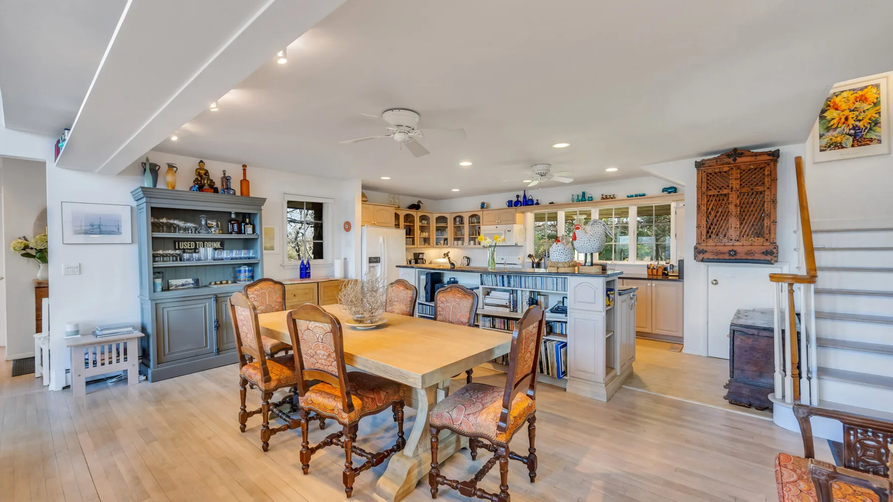 A dining area with a wooden table and chairs beside a kitchen island.