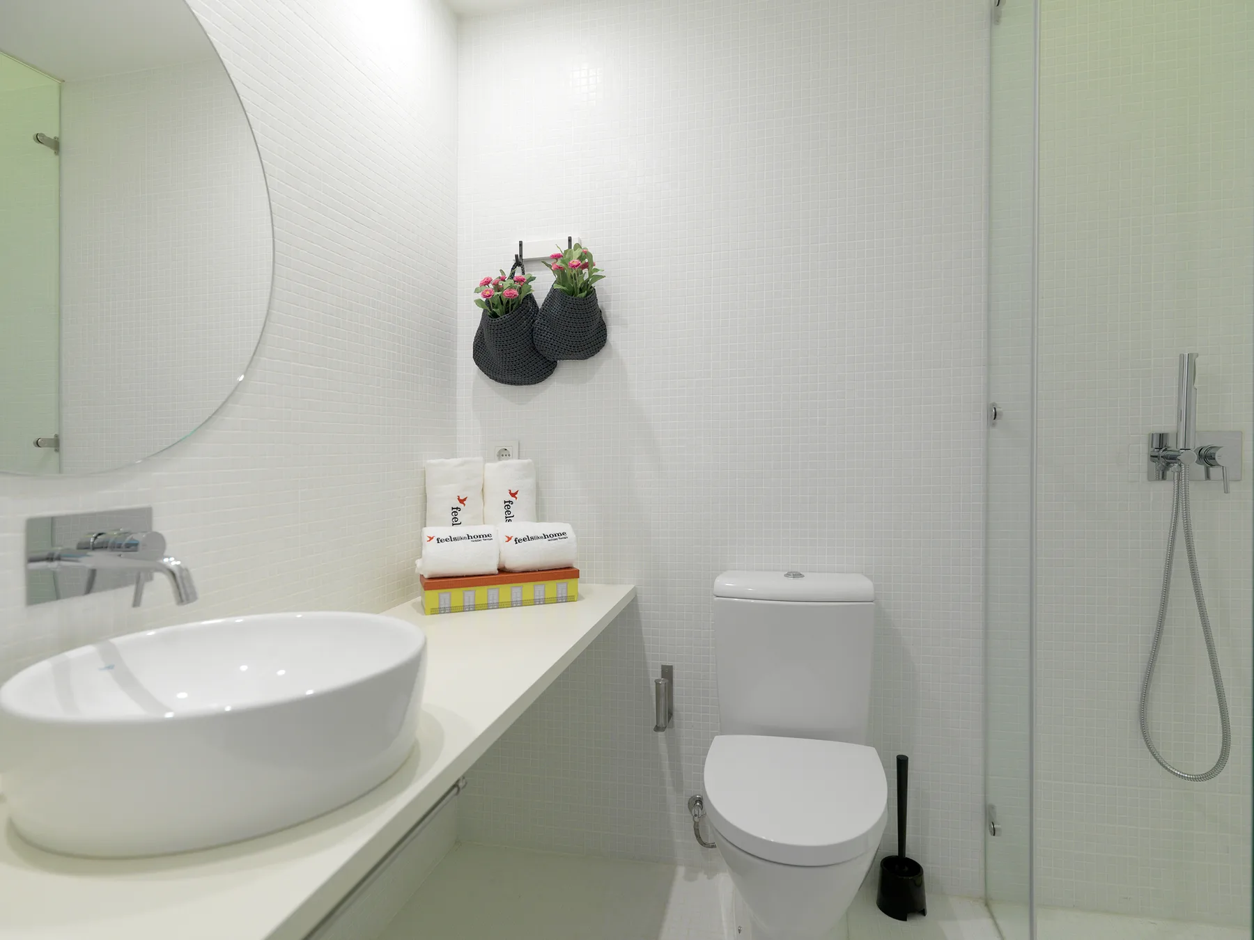 A bright bathroom with a sink, toilet, and glass shower.