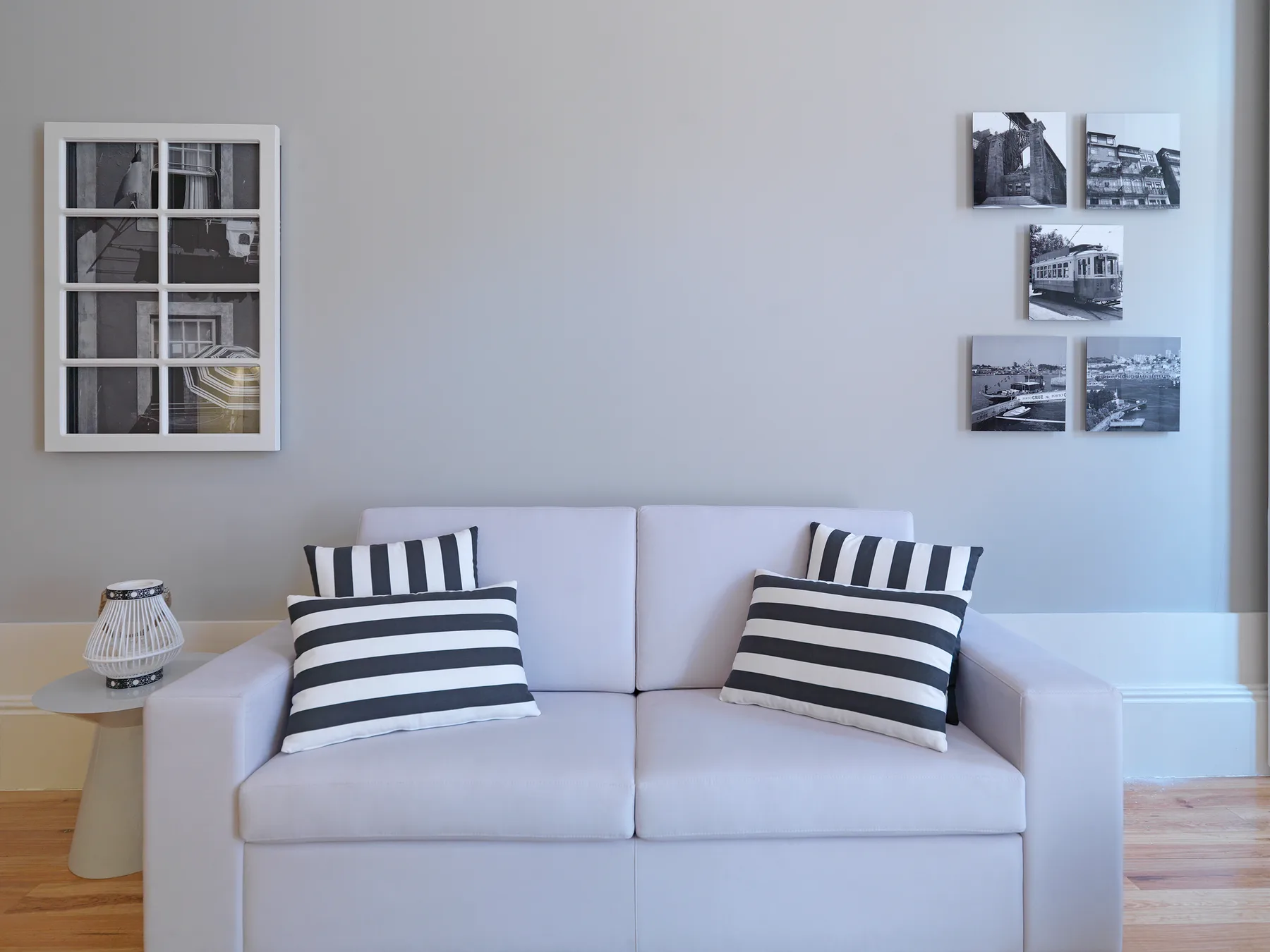 A living room with a white sofa and framed photographs on the wall.