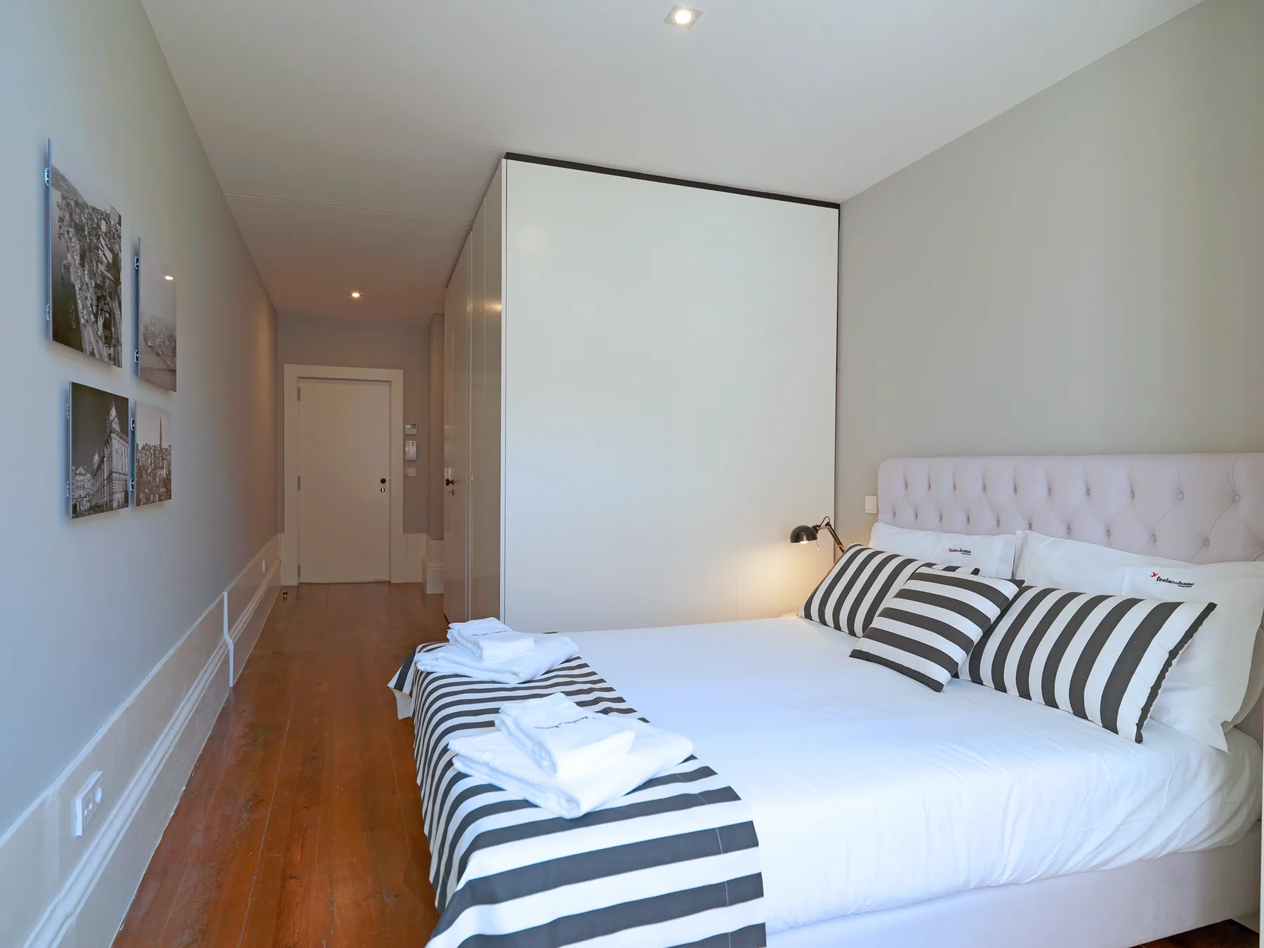 A bedroom with a neatly made bed and striped pillows.