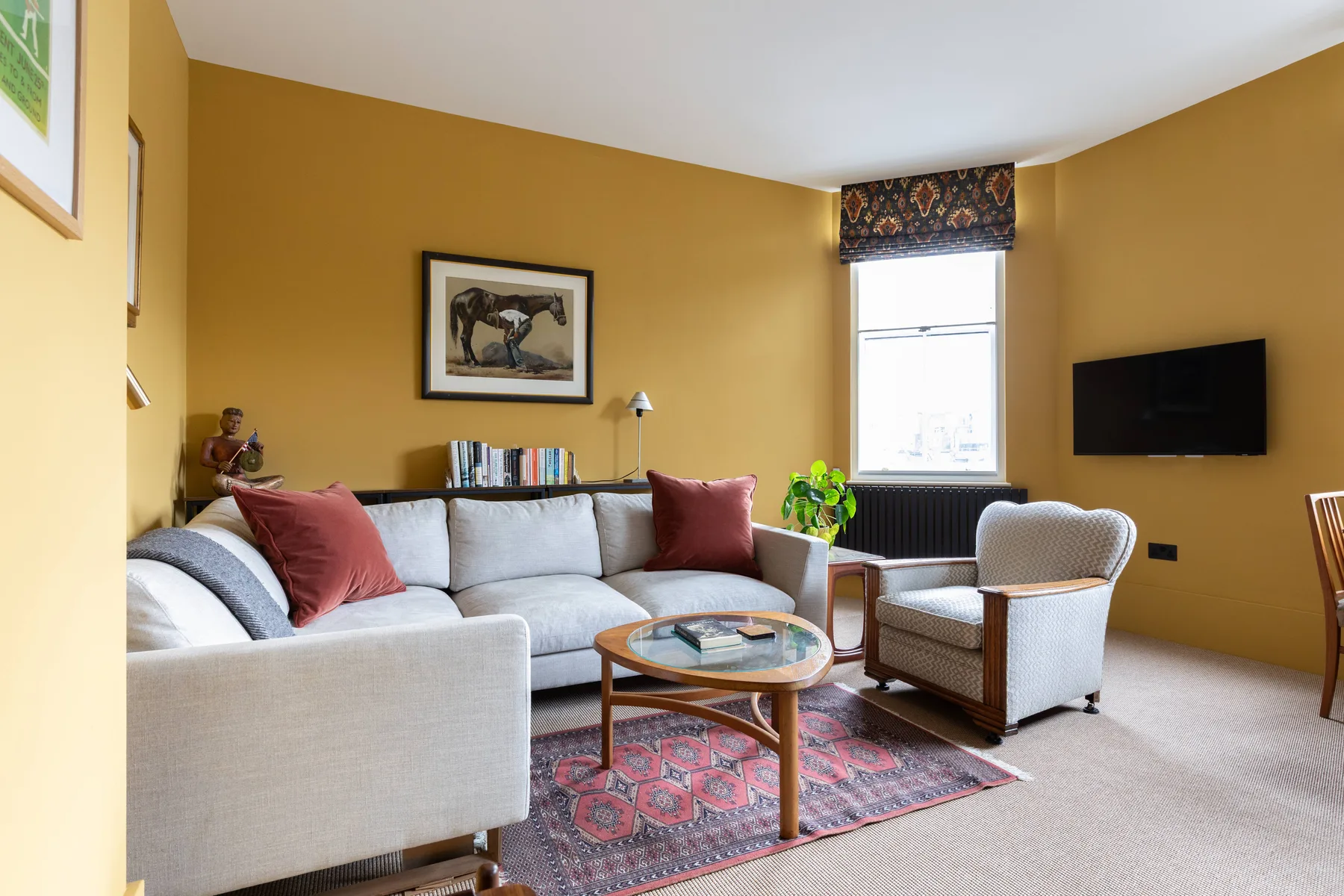 Una sala de estar con un sofá claro, un sillón y una mesa de centro.