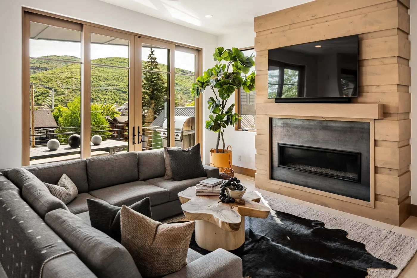 A bright living room with a sectional seating area and a fireplace.