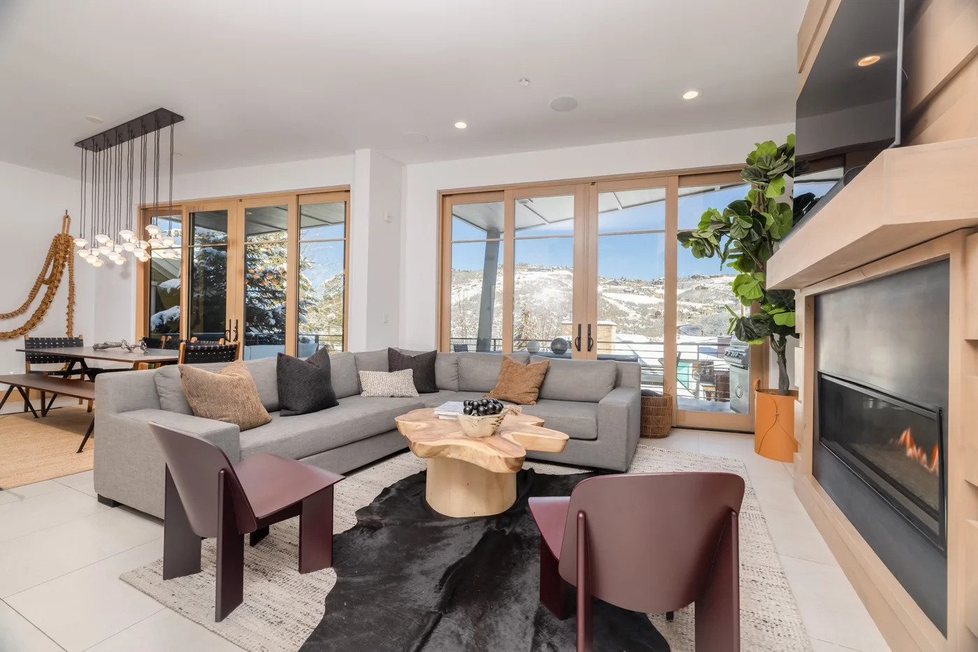 A bright living room with sectional seating, a coffee table, and a fireplace.