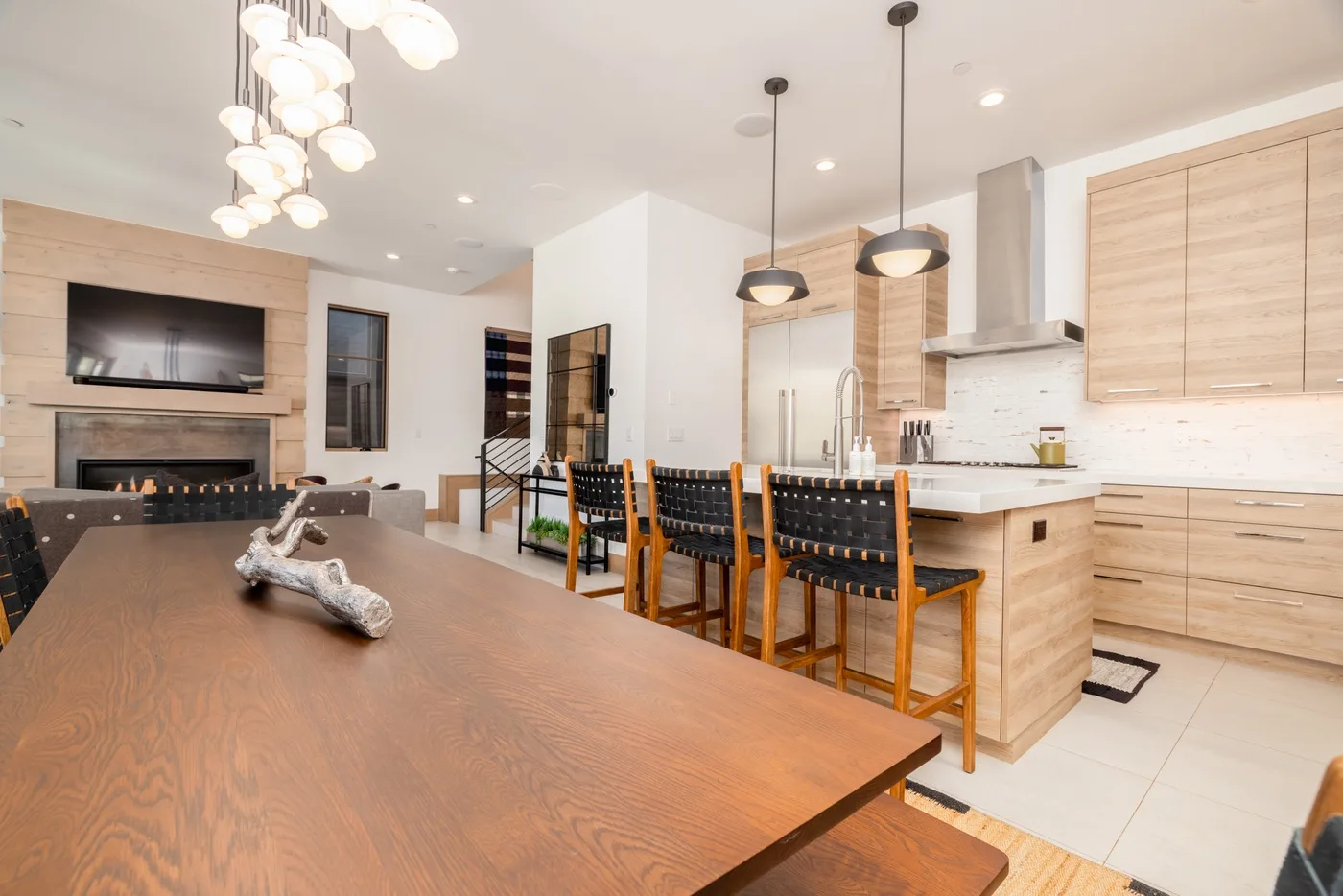 An open-plan dining and kitchen area with a large wooden table and island.