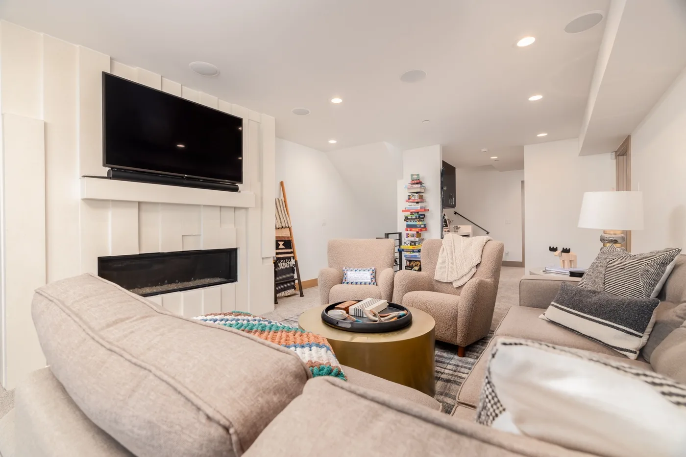 A bright living room with a wall-mounted television and comfortable seating.