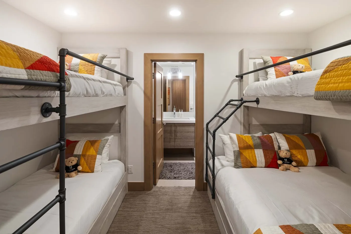 A bedroom with bunk beds on both sides and a doorway at the far end.