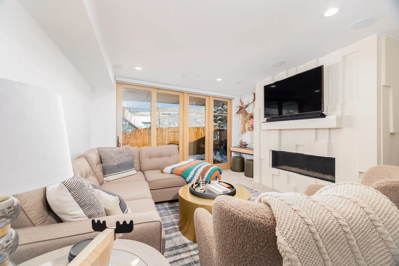 A bright living room with seating arranged around a coffee table and fireplace.