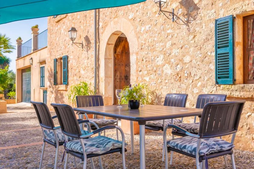 Una mesa de comedor y asientos al aire libre junto a un edificio de piedra.