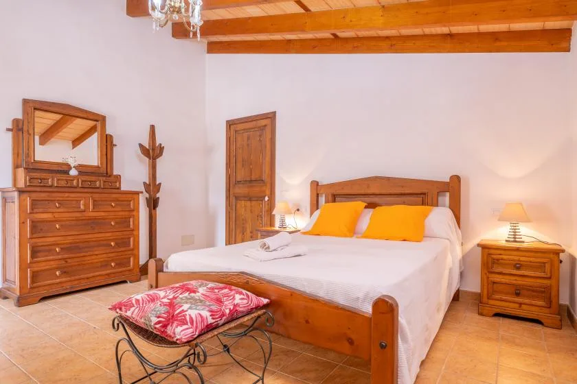 Un dormitorio con una cama de madera, una cómoda y una mesita de noche.