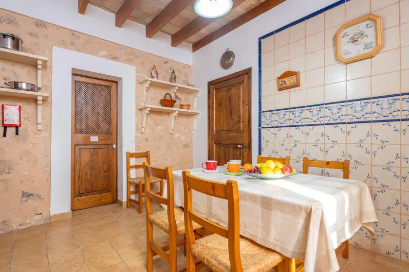 Un comedor con una mesa puesta y sillas de madera.