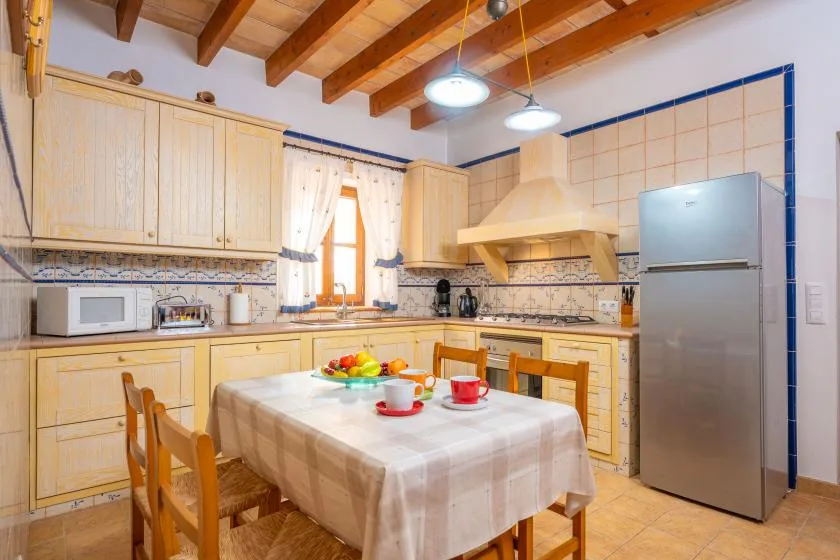 Una cocina luminosa con gabinetes de madera clara y una mesa de comedor.