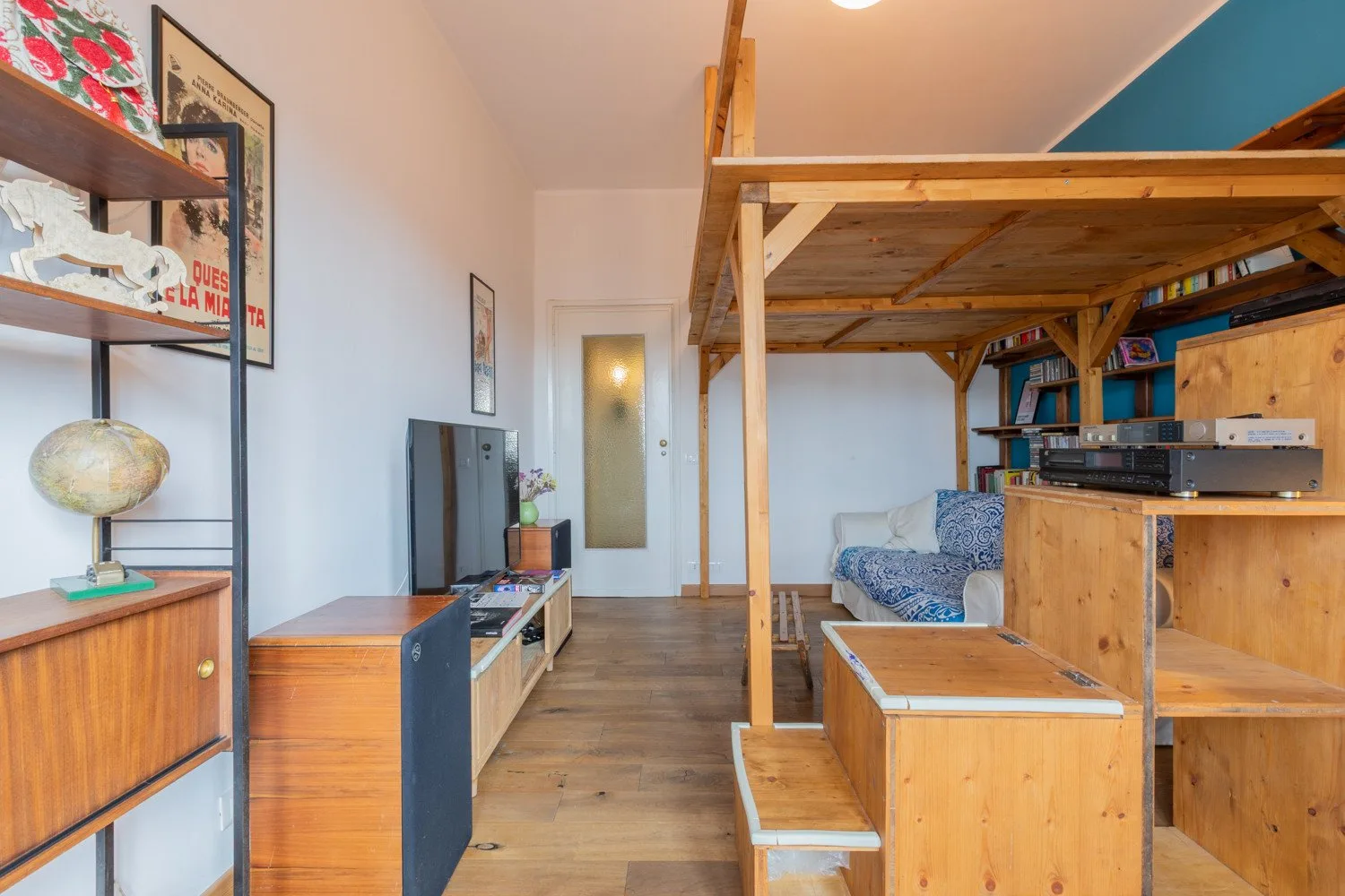 Una pequeña sala de estar con una plataforma elevada de madera y asientos.