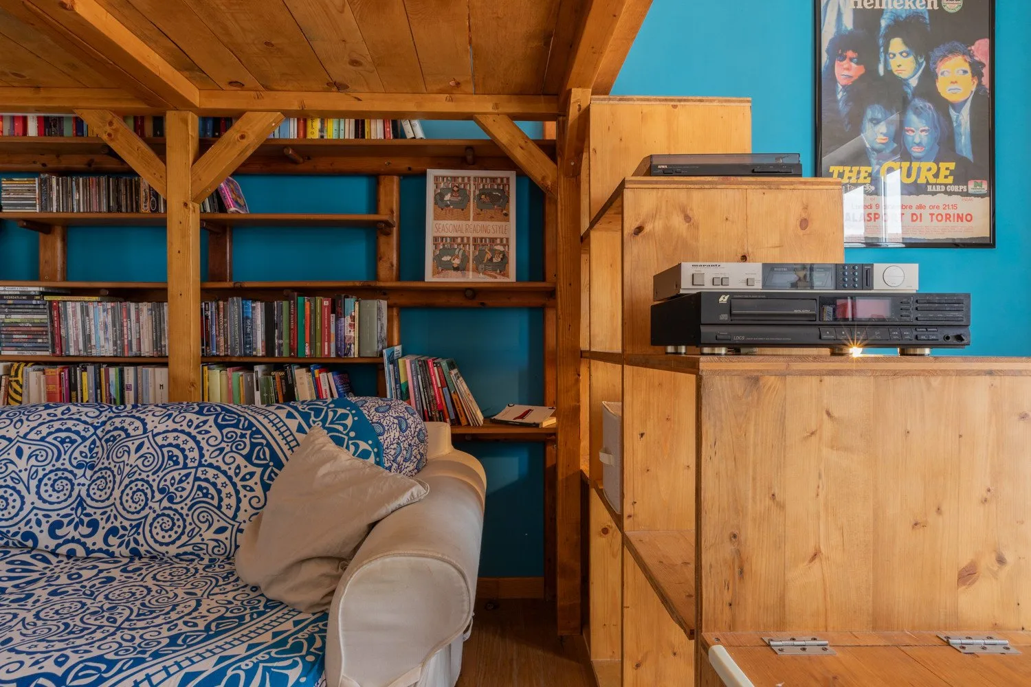 Una sala de estar con asientos estampados, estanterías y un mueble de entretenimiento de madera.