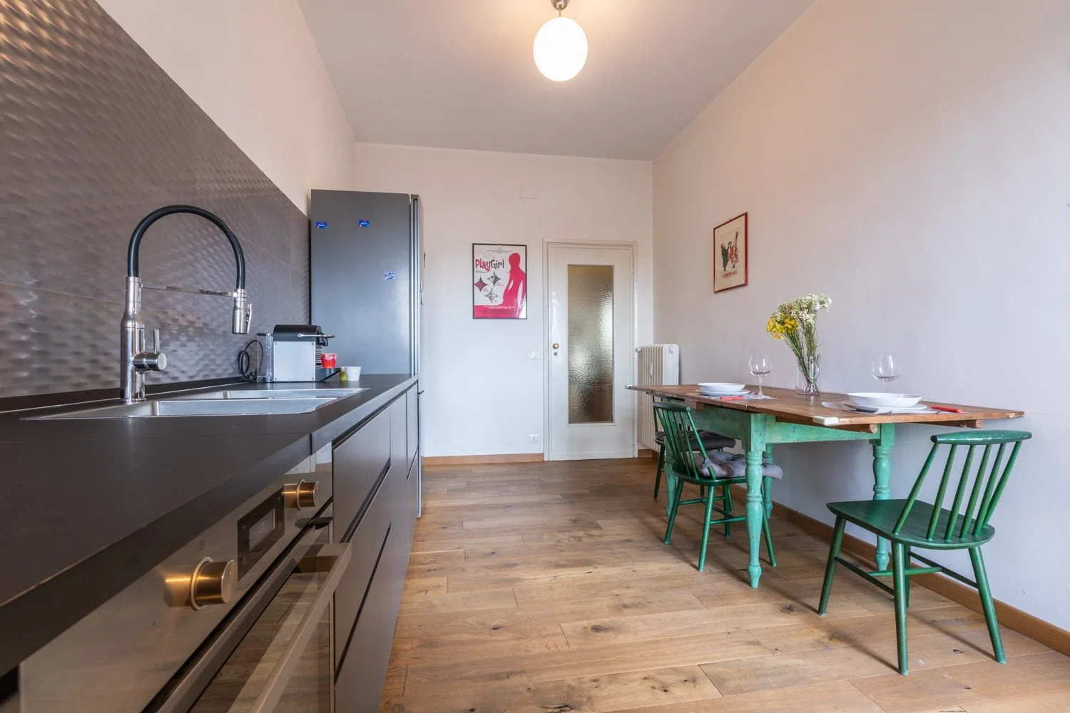 Una cocina y comedor con una encimera oscura y una mesa de madera.
