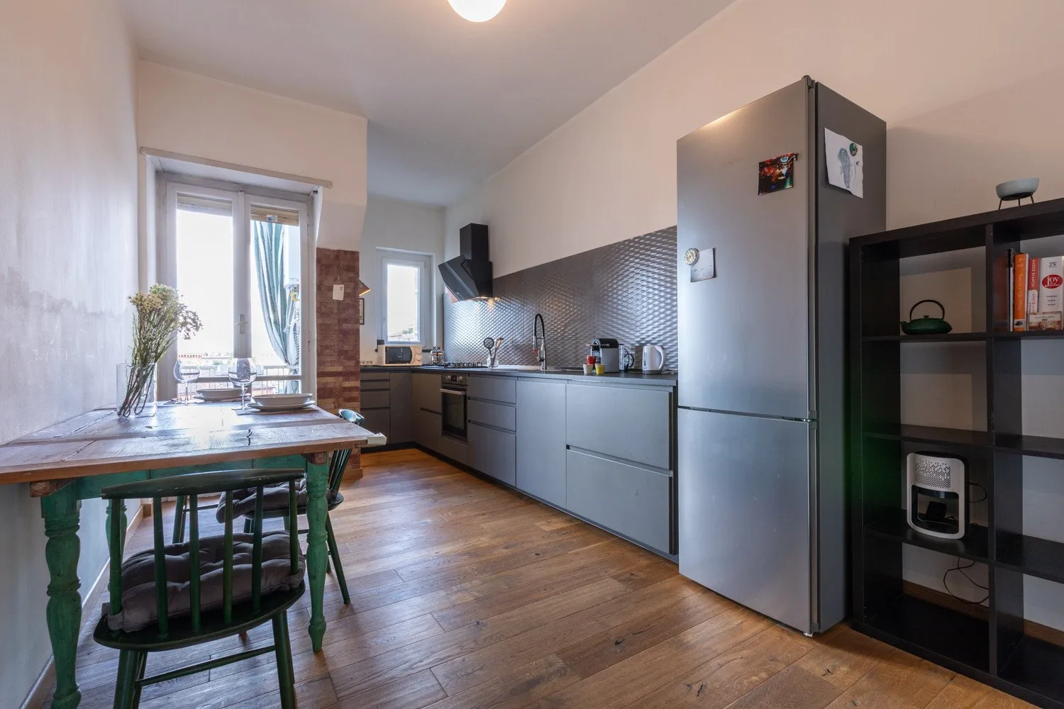 Cocina y comedor con una mesa junto a la ventana y encimeras a lo largo de la pared.
