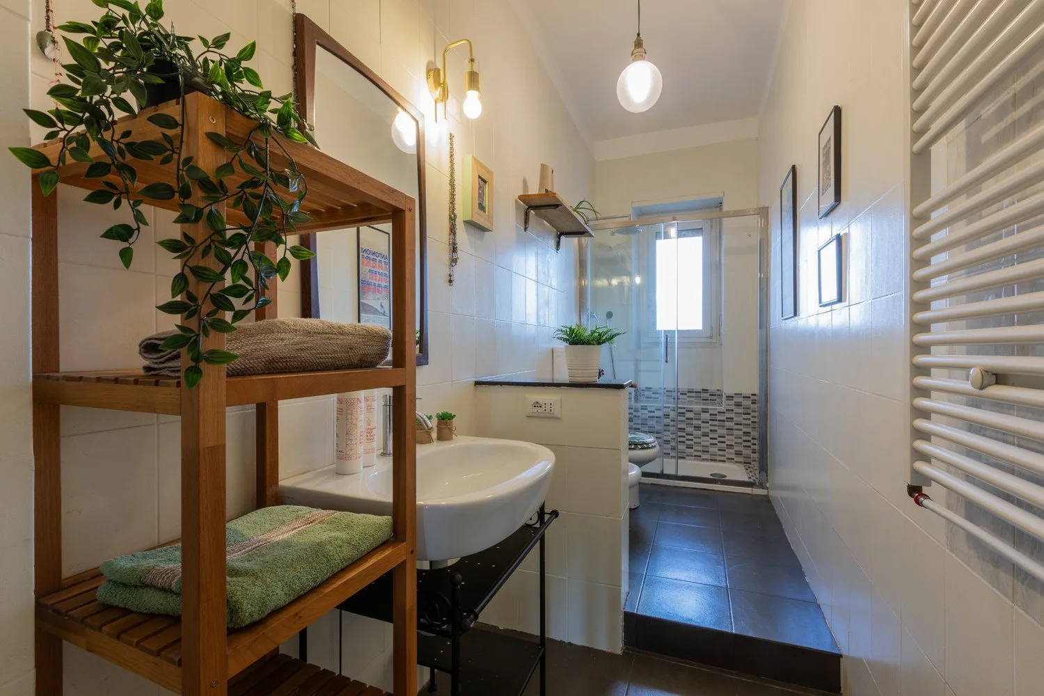Un baño con azulejos, lavabo y una ducha de vidrio al fondo.