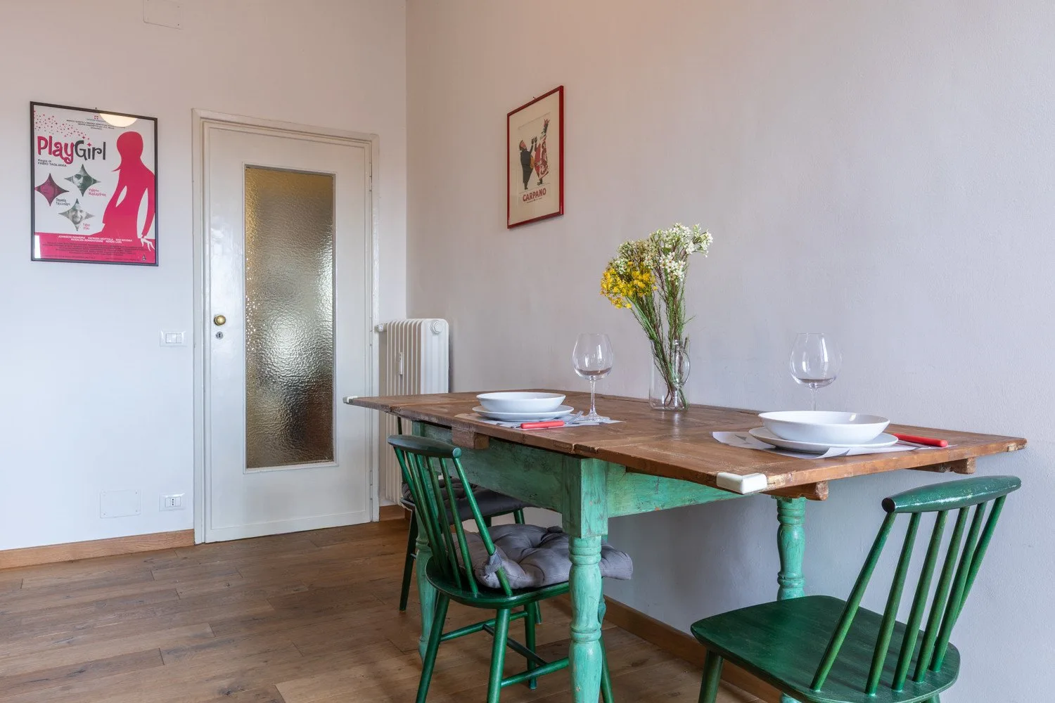 Un comedor con una mesa de madera puesta con platos y flores.