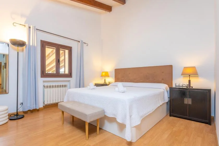 Un dormitorio con una cama doble, lámparas de mesilla y una ventana.