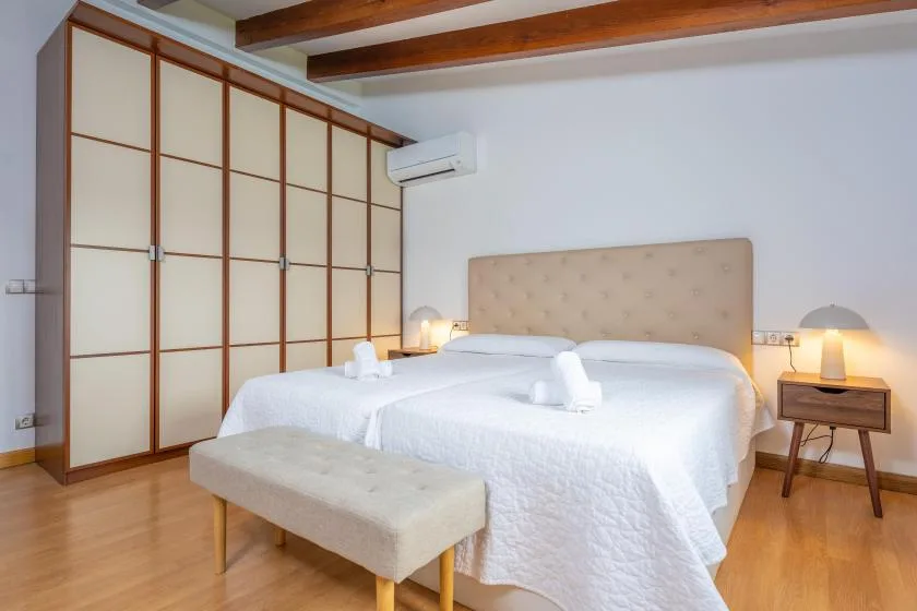 Un dormitorio con una cama bien tendida y armarios empotrados.