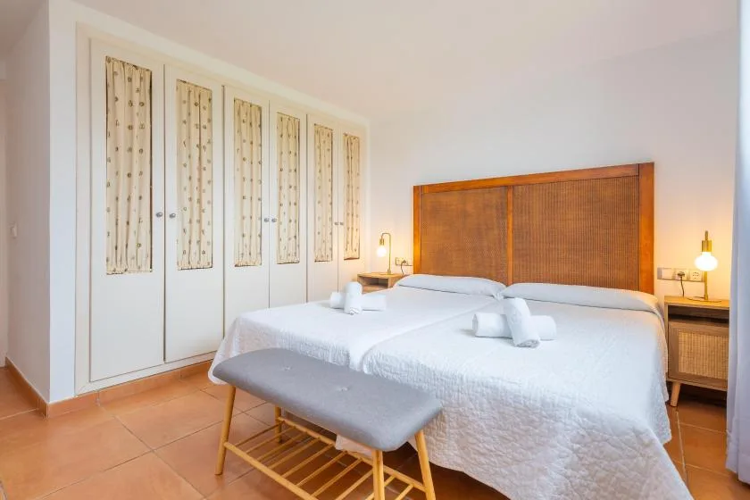 Un dormitorio con dos camas y un cabecero tejido.