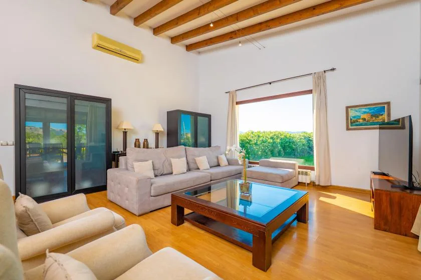 Una sala luminosa con asientos dispuestos alrededor de una mesa de centro con tapa de vidrio.