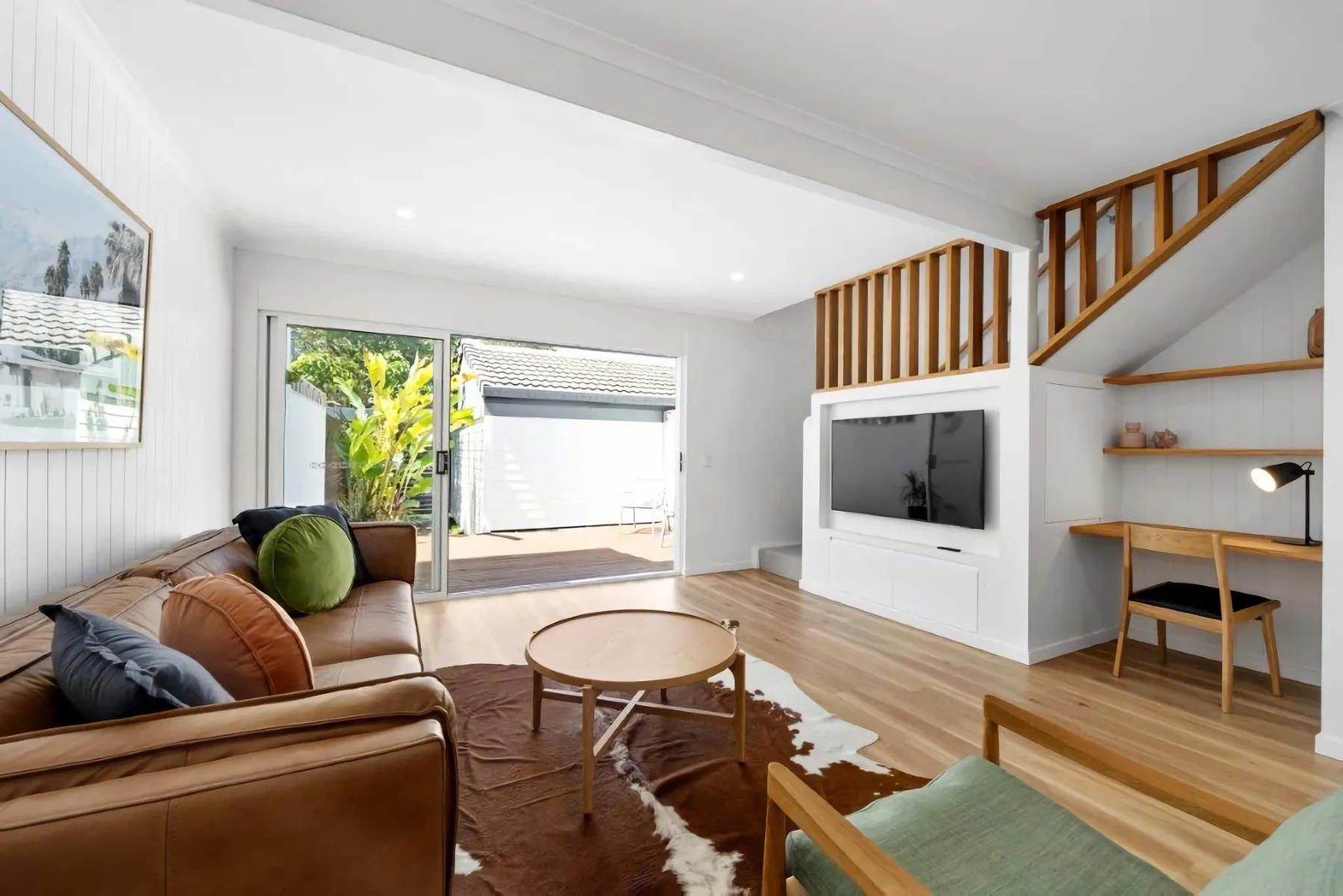 A living room with seating, a television, and sliding glass doors.