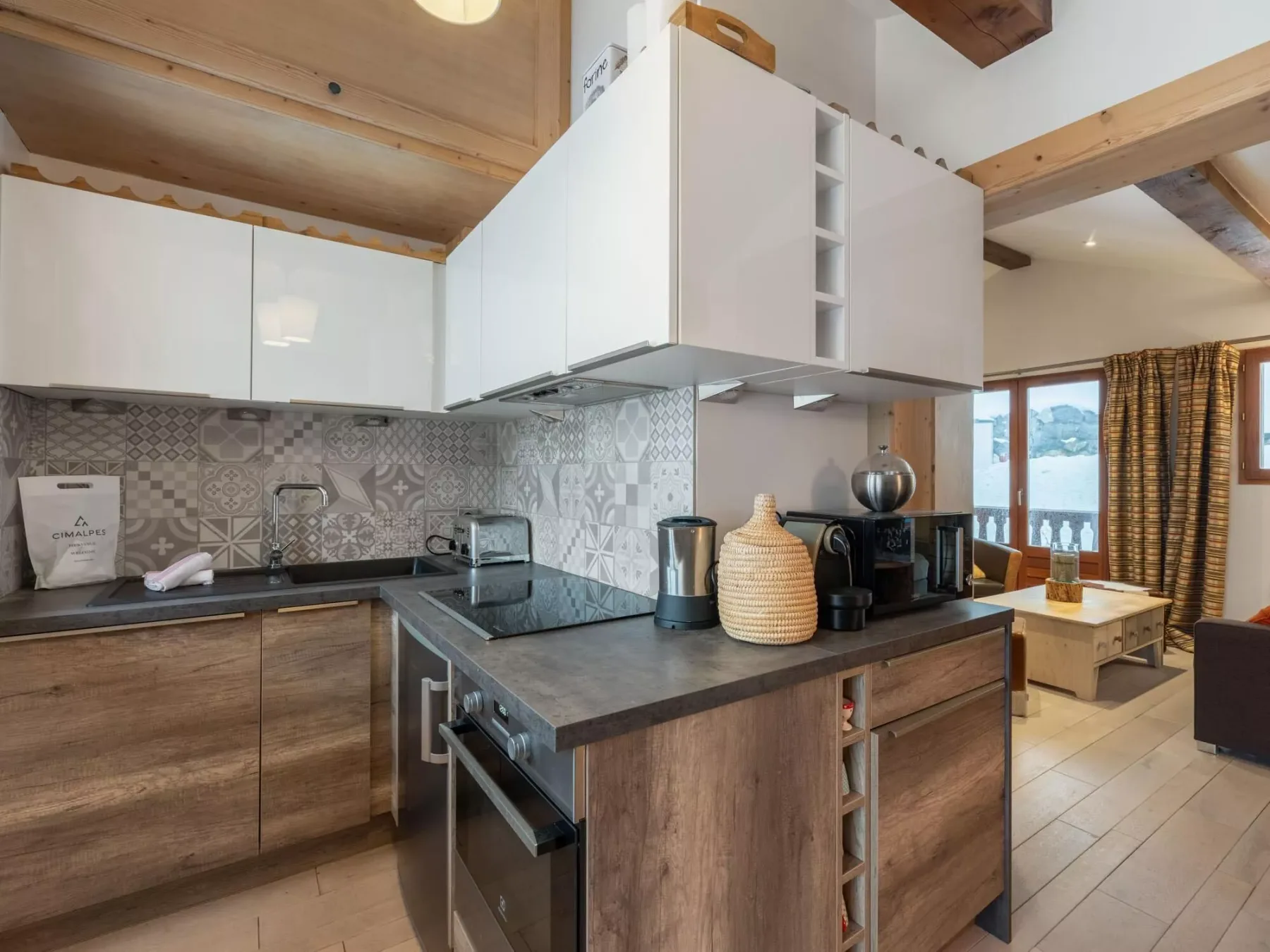 A compact kitchen with wood cabinets, a dark countertop, and white overhead cupboards.