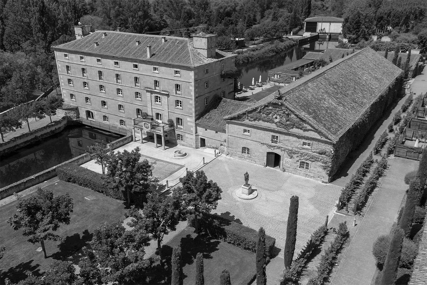 Vista aérea del hotel histórico, el canal, el jardín y el patio.