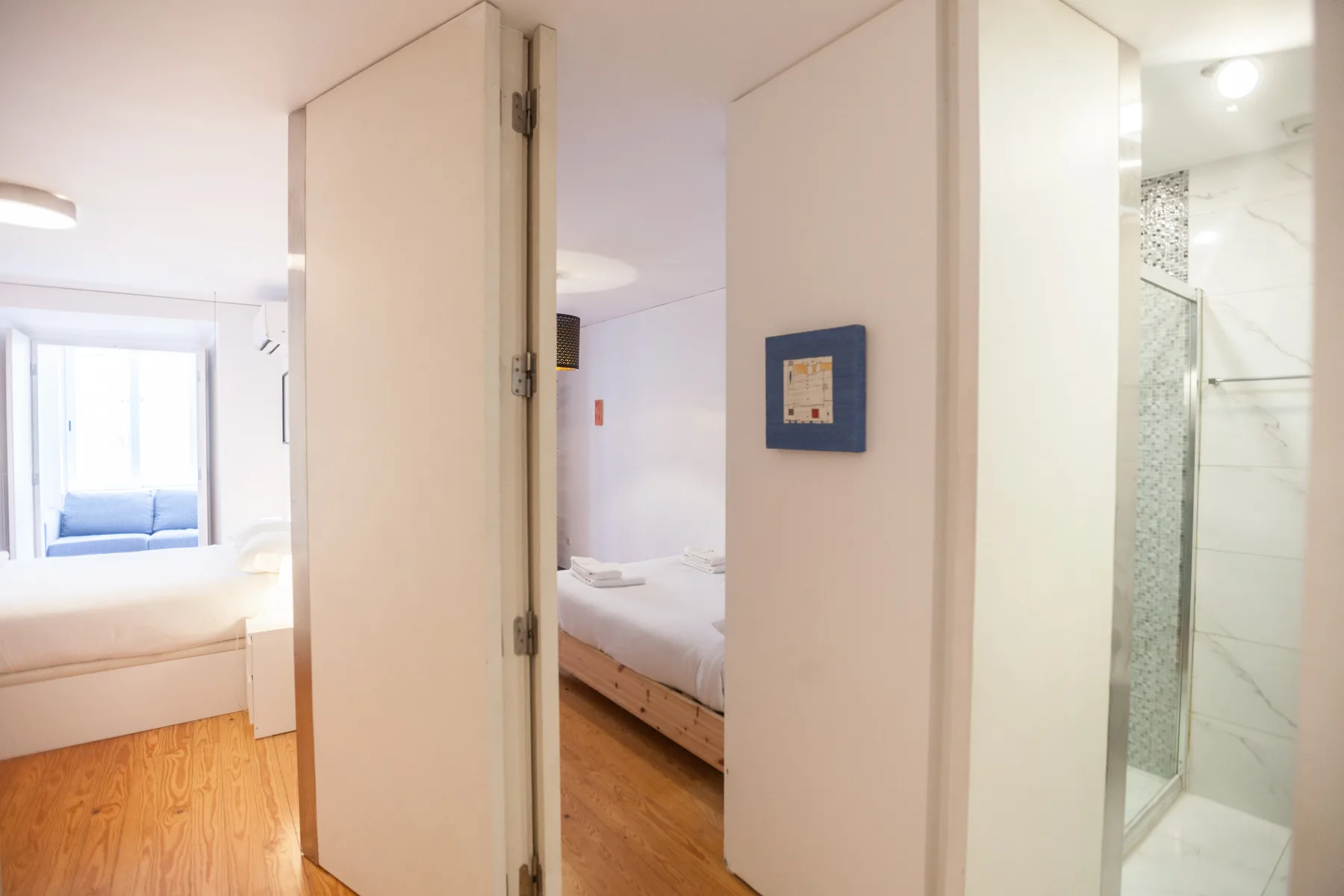 A bedroom with a bed and a view into the adjoining bathroom.
