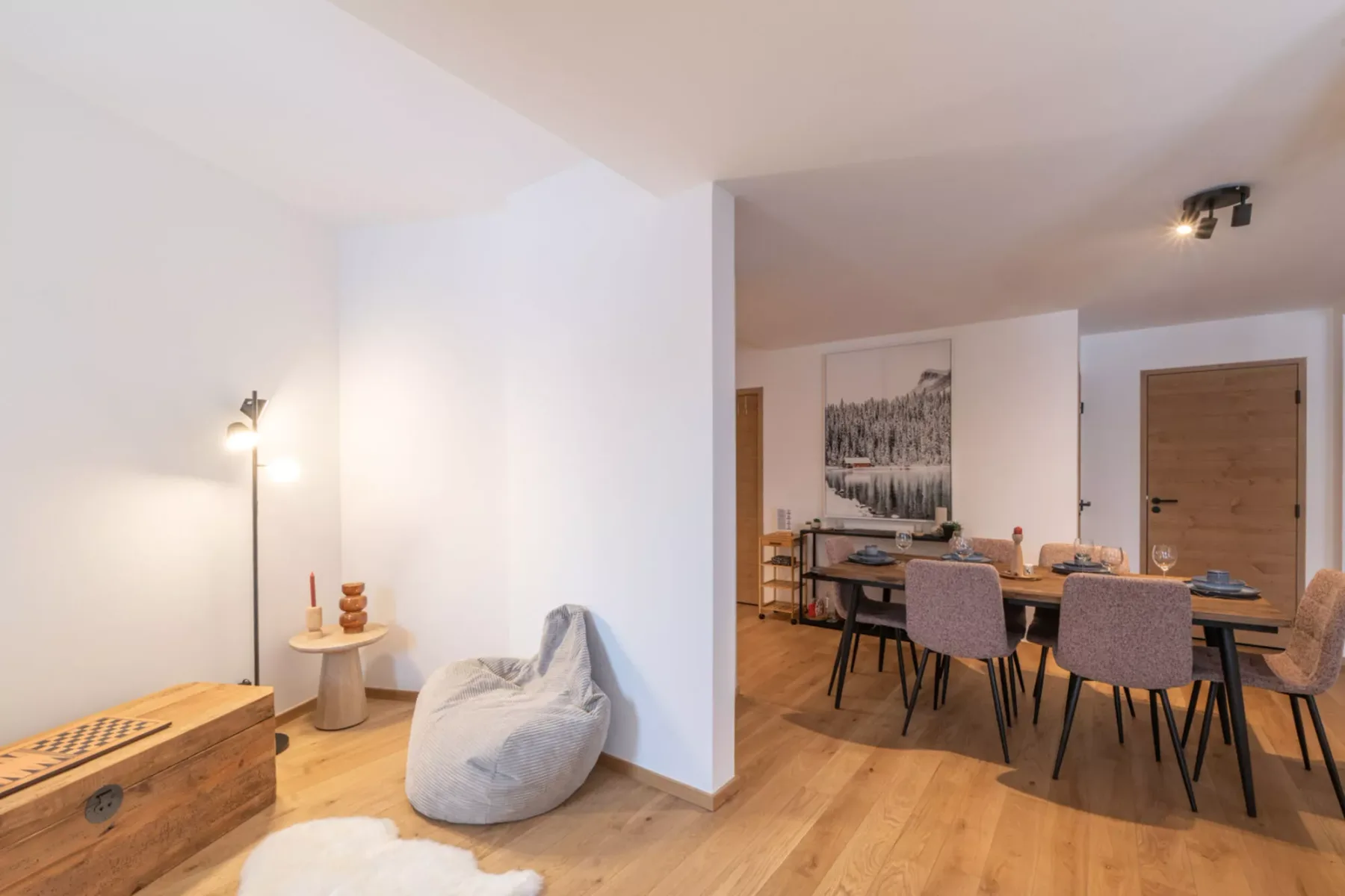 An open-plan dining area with a table and chairs beside a cozy seating nook.