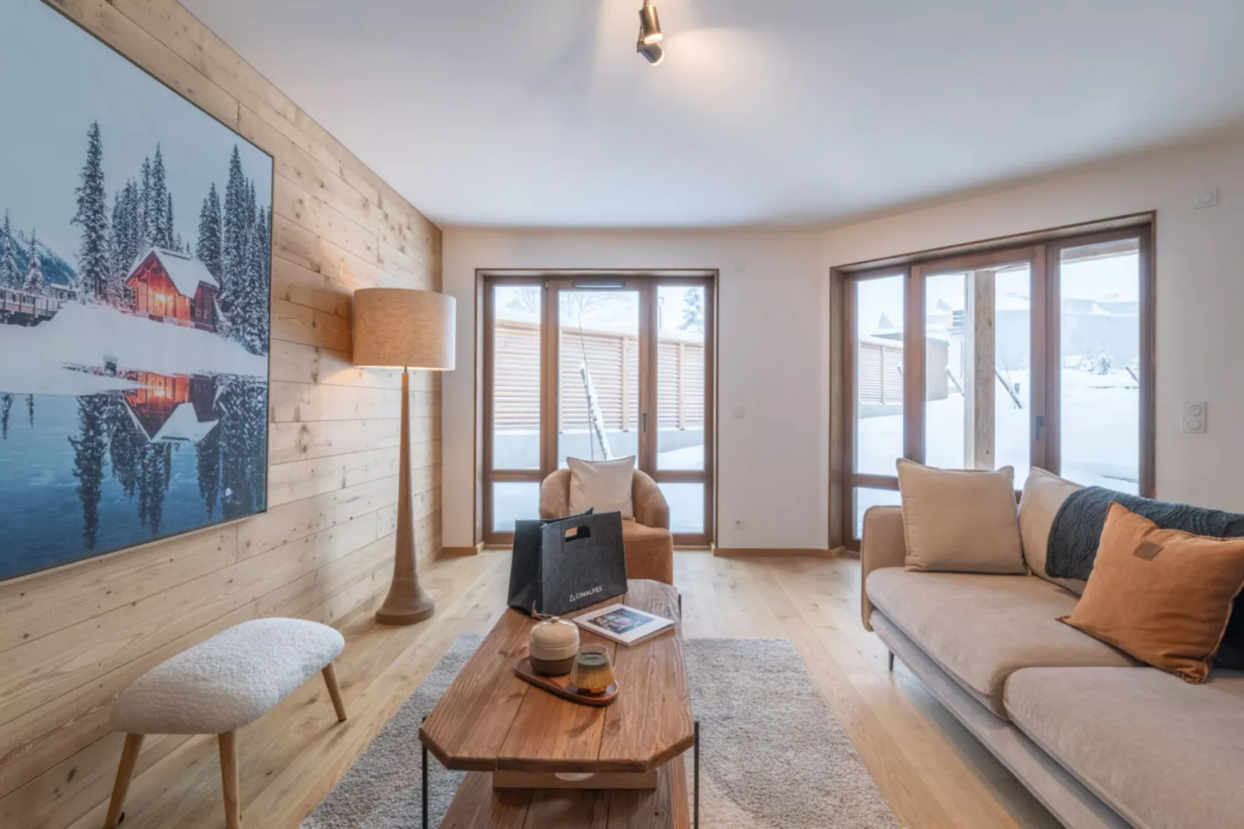 A bright living room with seating, a coffee table, and large windows.